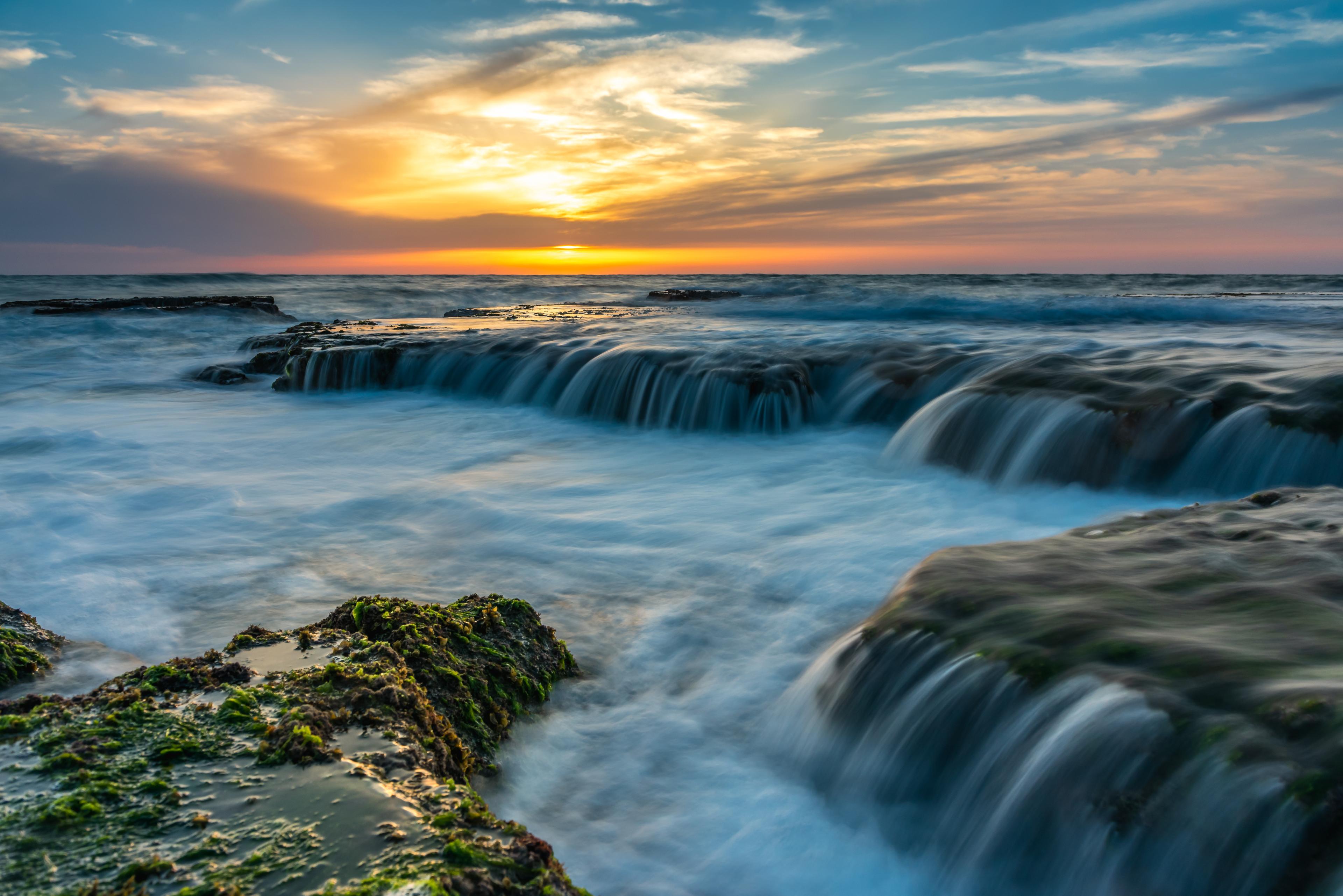 A photograph of cliffs with water running over them